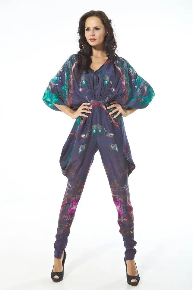 Model wearing a silk jumpsuit in Gotham City and Batmobile print with cowl-style side seams and a gathered waist.